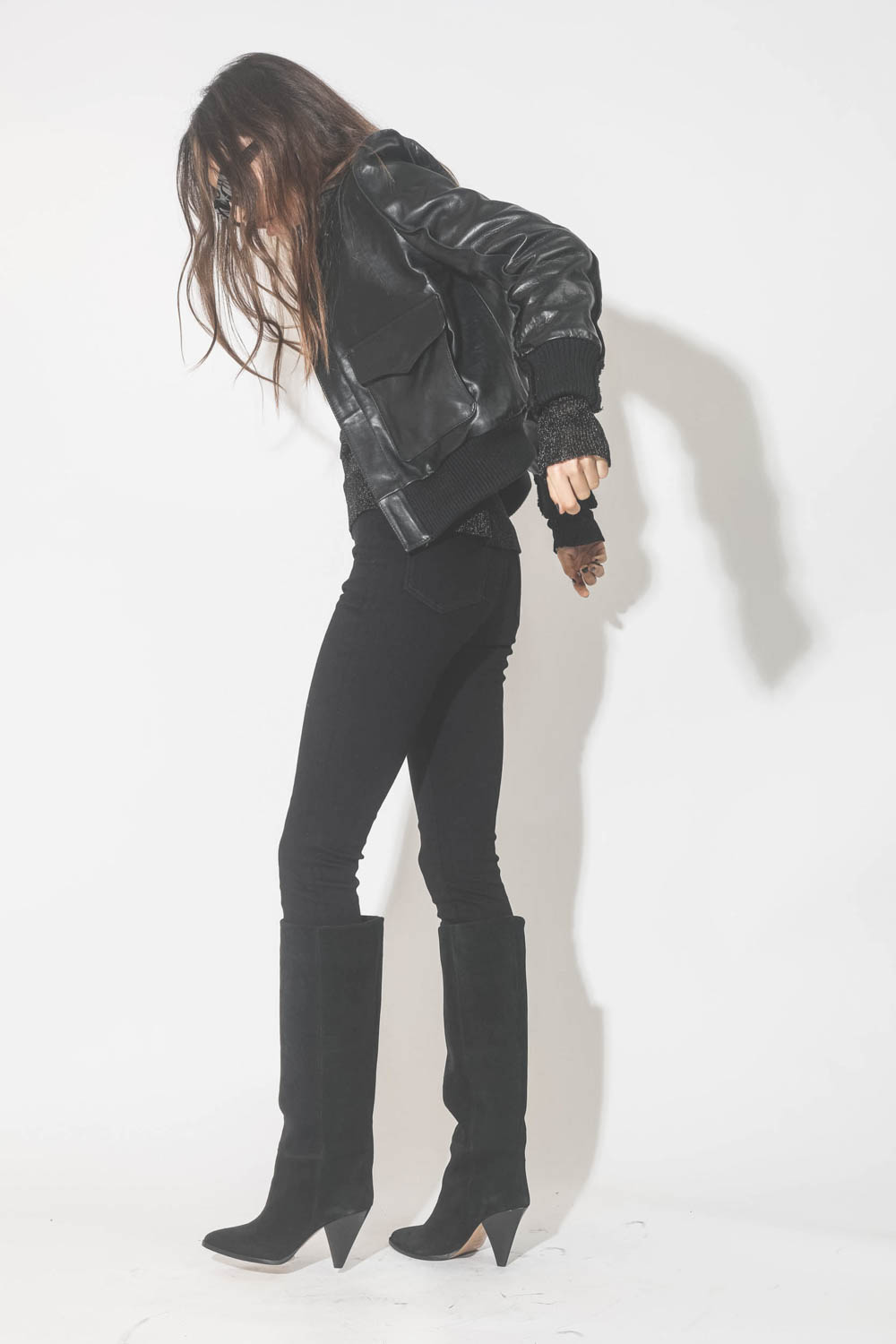Blouson en cuir brillant noir R13. Porté de profil.