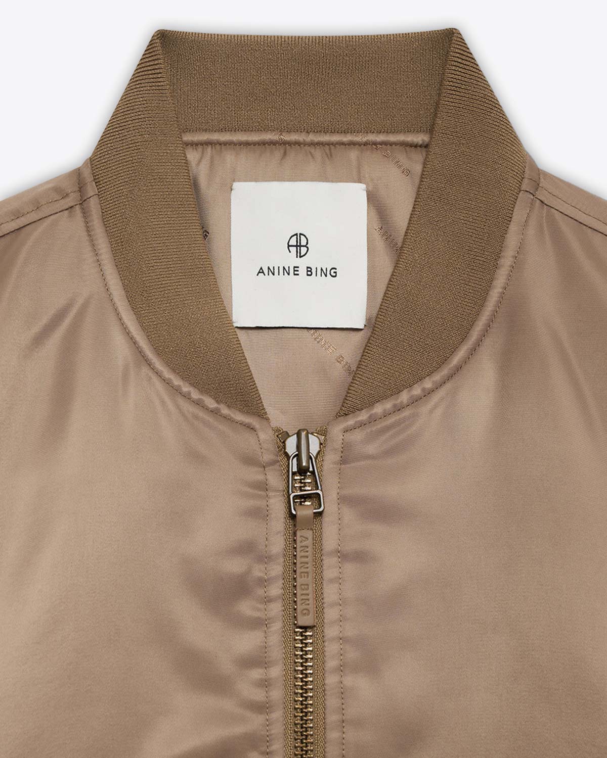 Blouson en nylon beige doré Sépia Léon Anine Bing. Détail du col et zip avec languettes en cuir Anine Bing.