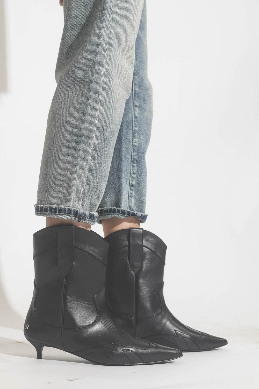 Boots en cuir noir esprit santiag petits talons bobines Rae Anine Bing. Porté avec un jeans bleu ciel.