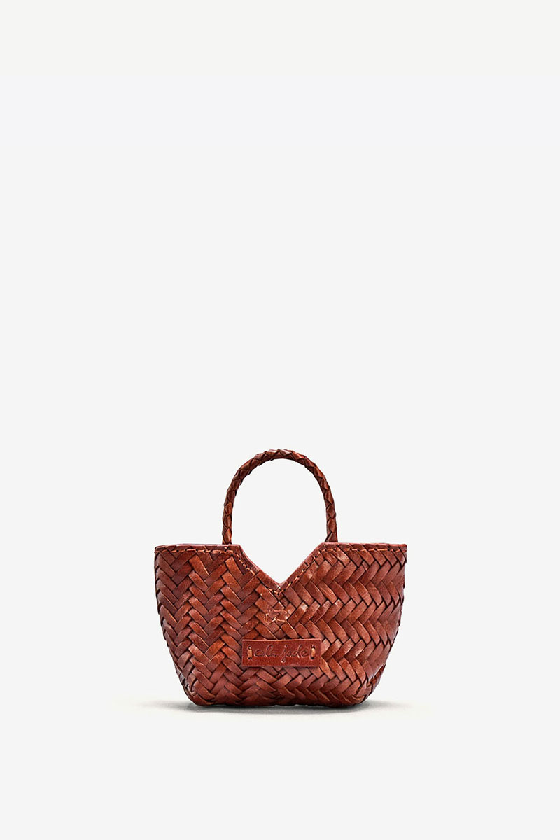 Charm Humi Micro Cala Jade en cuir tress&eacute; Nutmeg cognac vu de face. Bijou de sac.