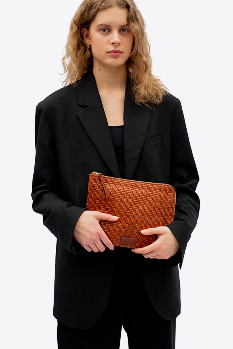 Pochette Batu S Twill Cala Jade en cuir tress&eacute; Nutmeg, port&eacute;e dans les mains.