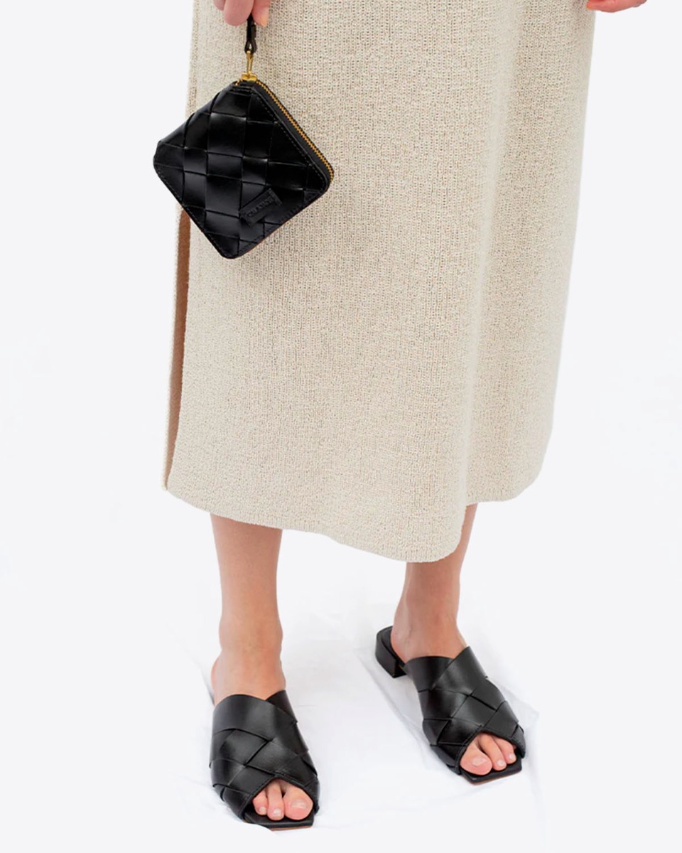 Portefeuille Iggi Cala Jade en cuir tress&eacute; noir, port&eacute; gr&acirc;ce &agrave; la tirette en cuir.