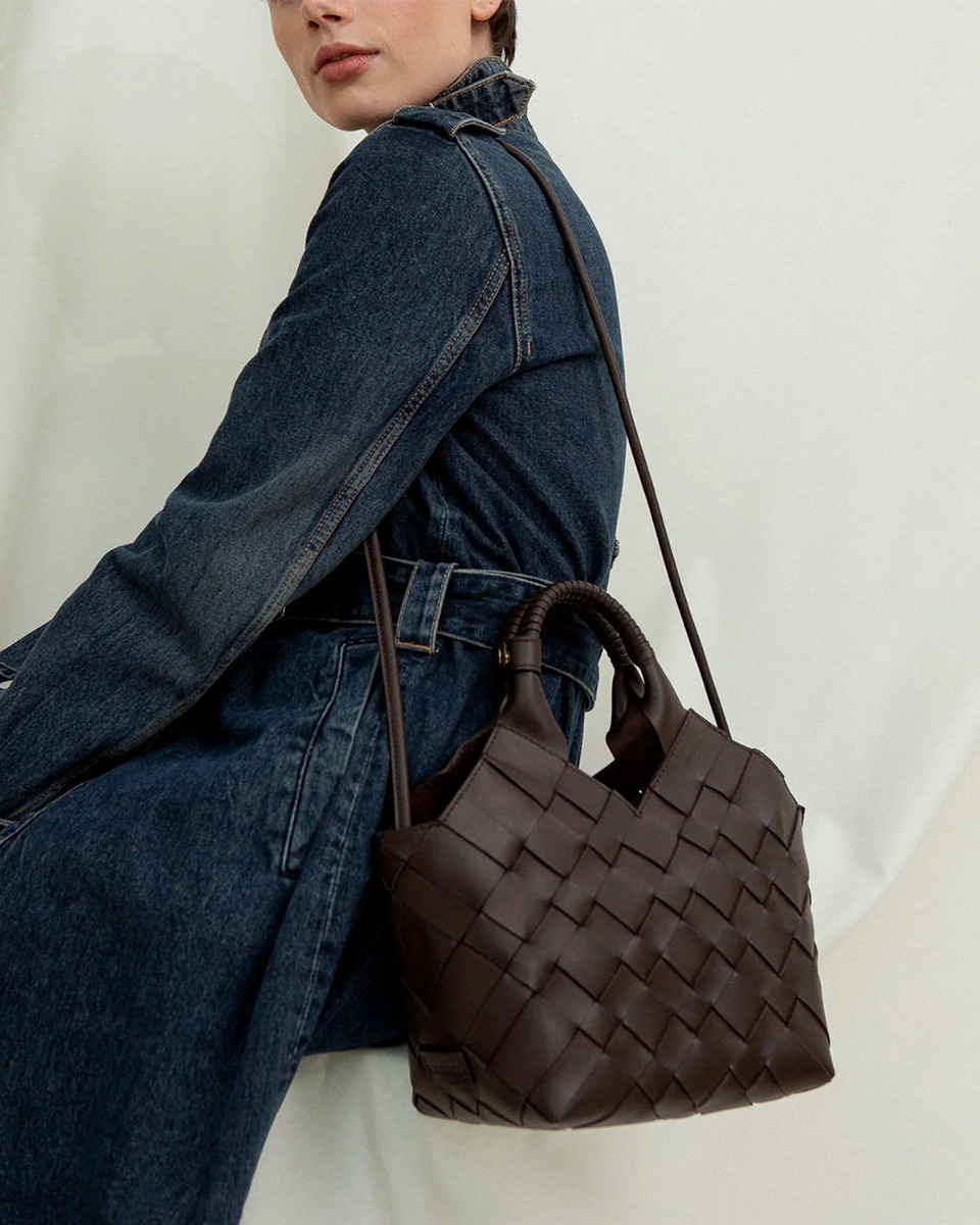 Sac Misu Cala Jade en cuir tress&eacute; noir, port&eacute; &agrave; l'&eacute;paule avec la bandouli&egrave;re longue.