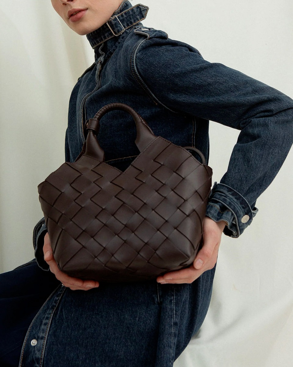 Sac Misu Cala Jade en cuir tress&eacute; noir, port&eacute; &agrave; la main. 