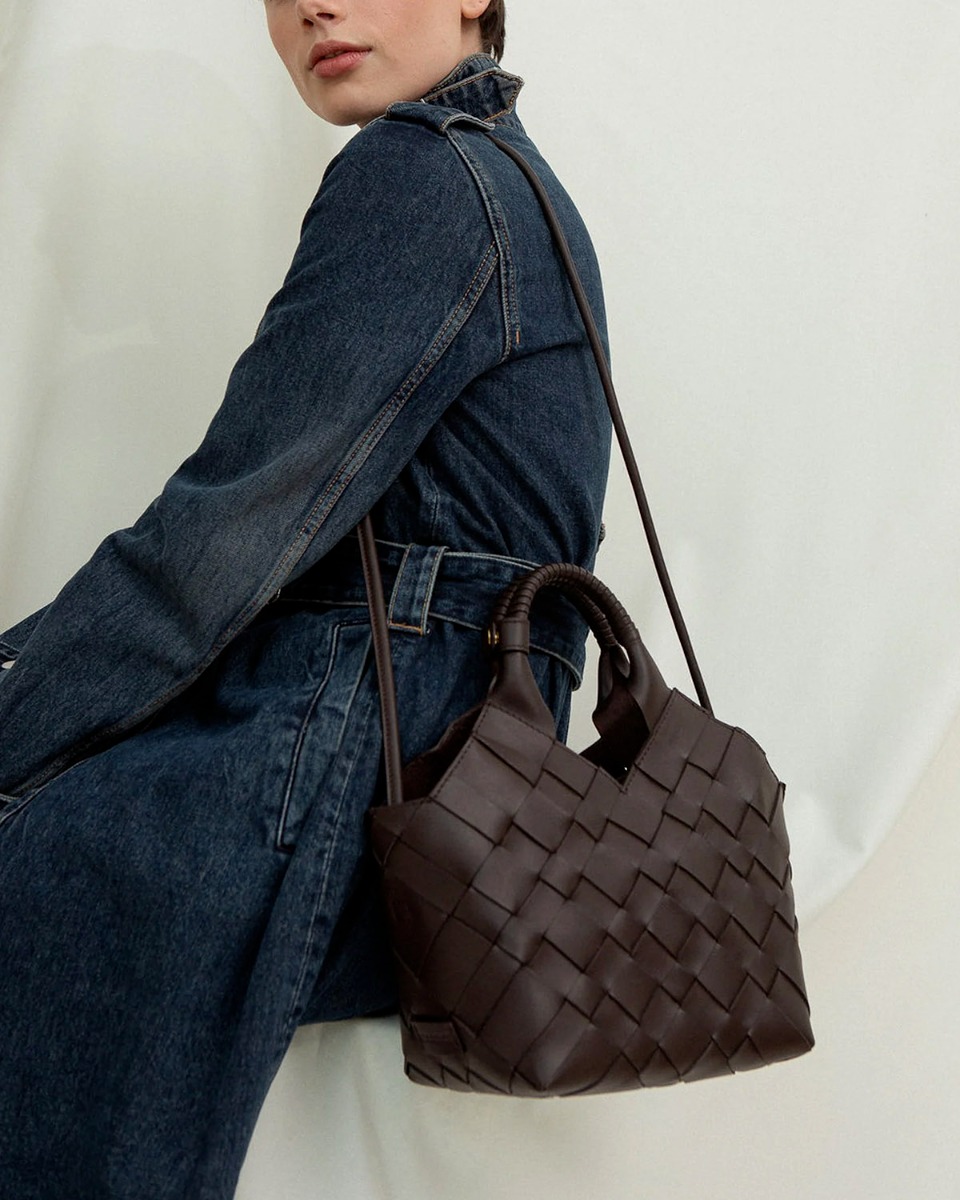Sac Misu Cala Jade en cuir tress&eacute; Umber (marron tr&egrave;s fonc&eacute;), port&eacute; &agrave; l'&eacute;paule avec la bandouli&egrave;re longue.