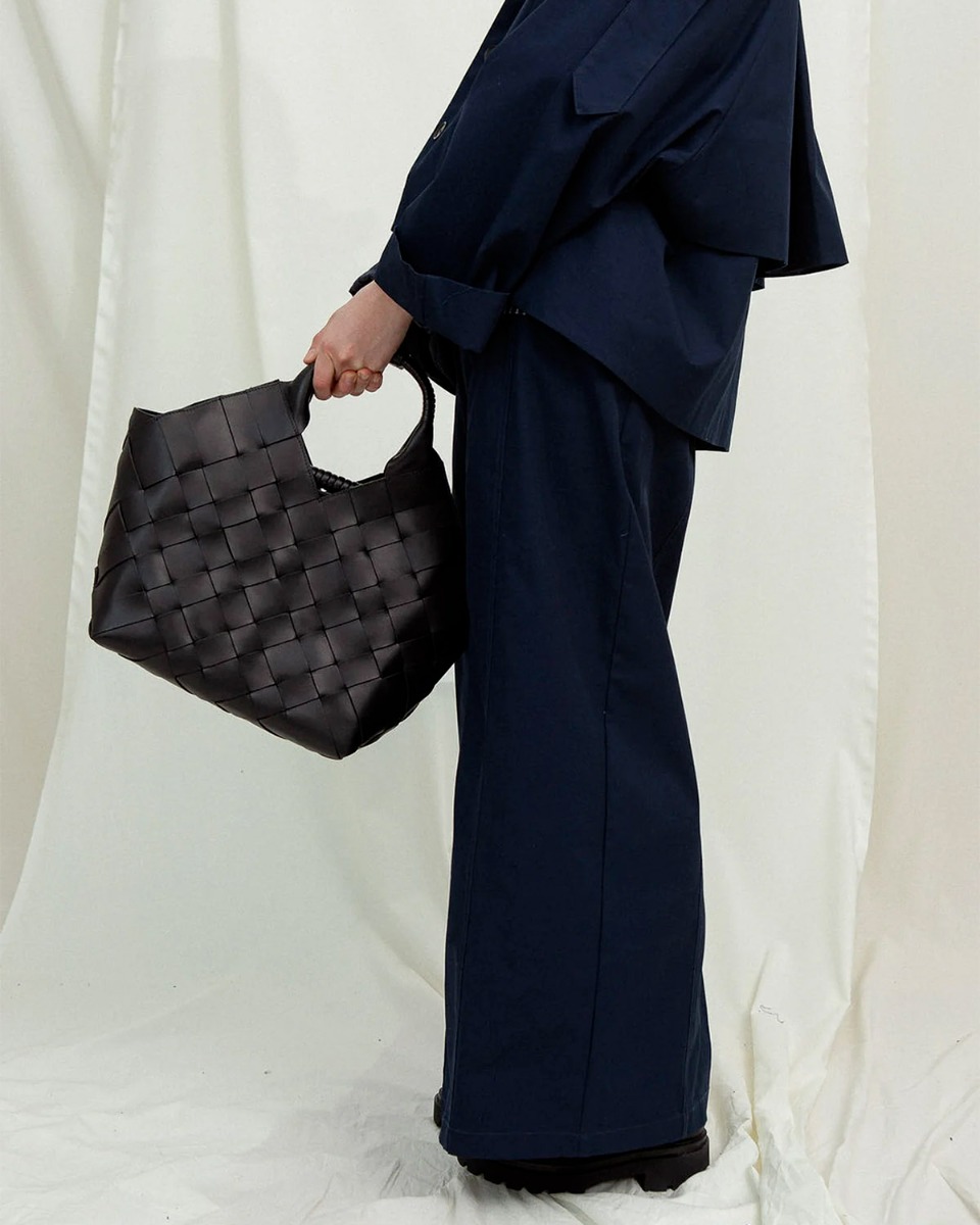 Sac Misu Large Cala Jade en cuir tress&eacute; noir, port&eacute; de profil.