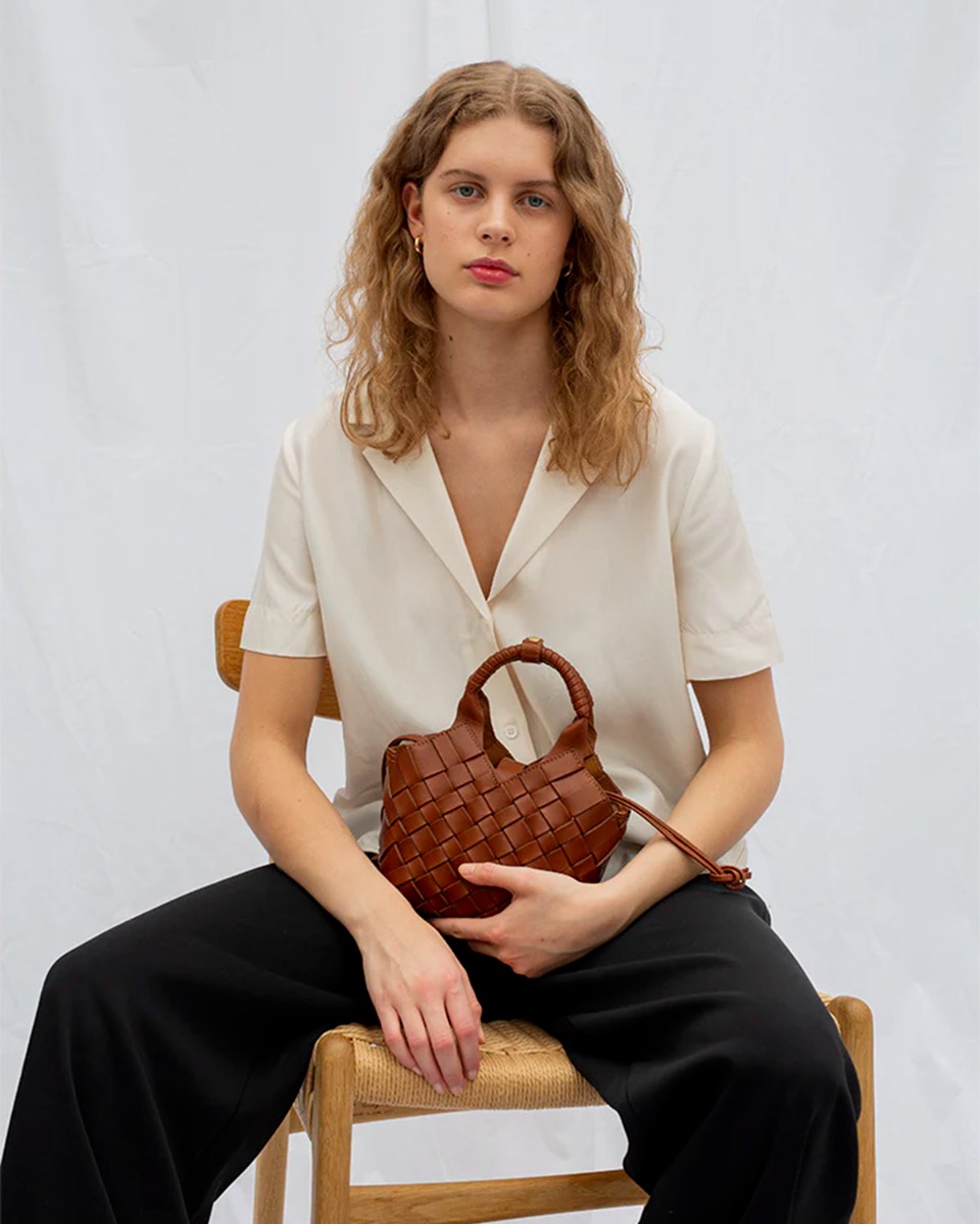 Sac Misu mini Cala Jade en cuir tress&eacute; Nutmeg, port&eacute; dans les mains.