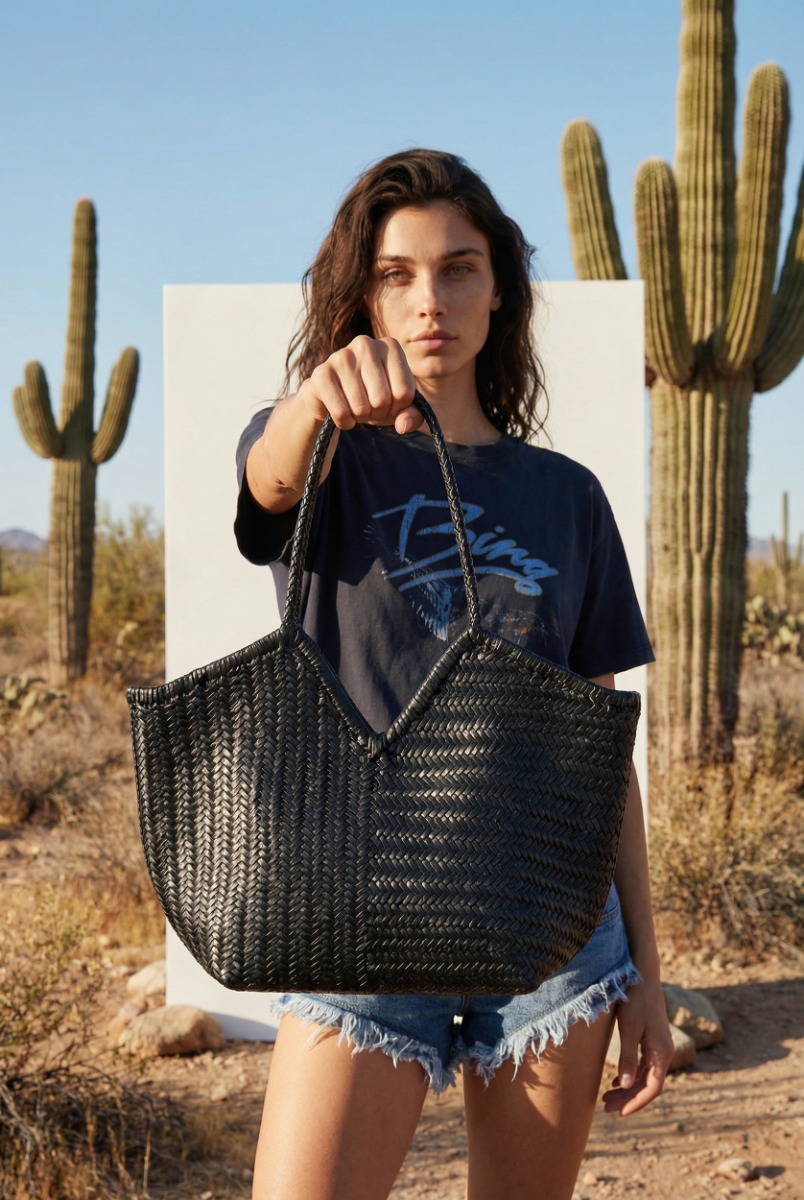 Sac cabas Humi Cala Jade en cuir tress&eacute; noir, port&eacute; &agrave; la main.