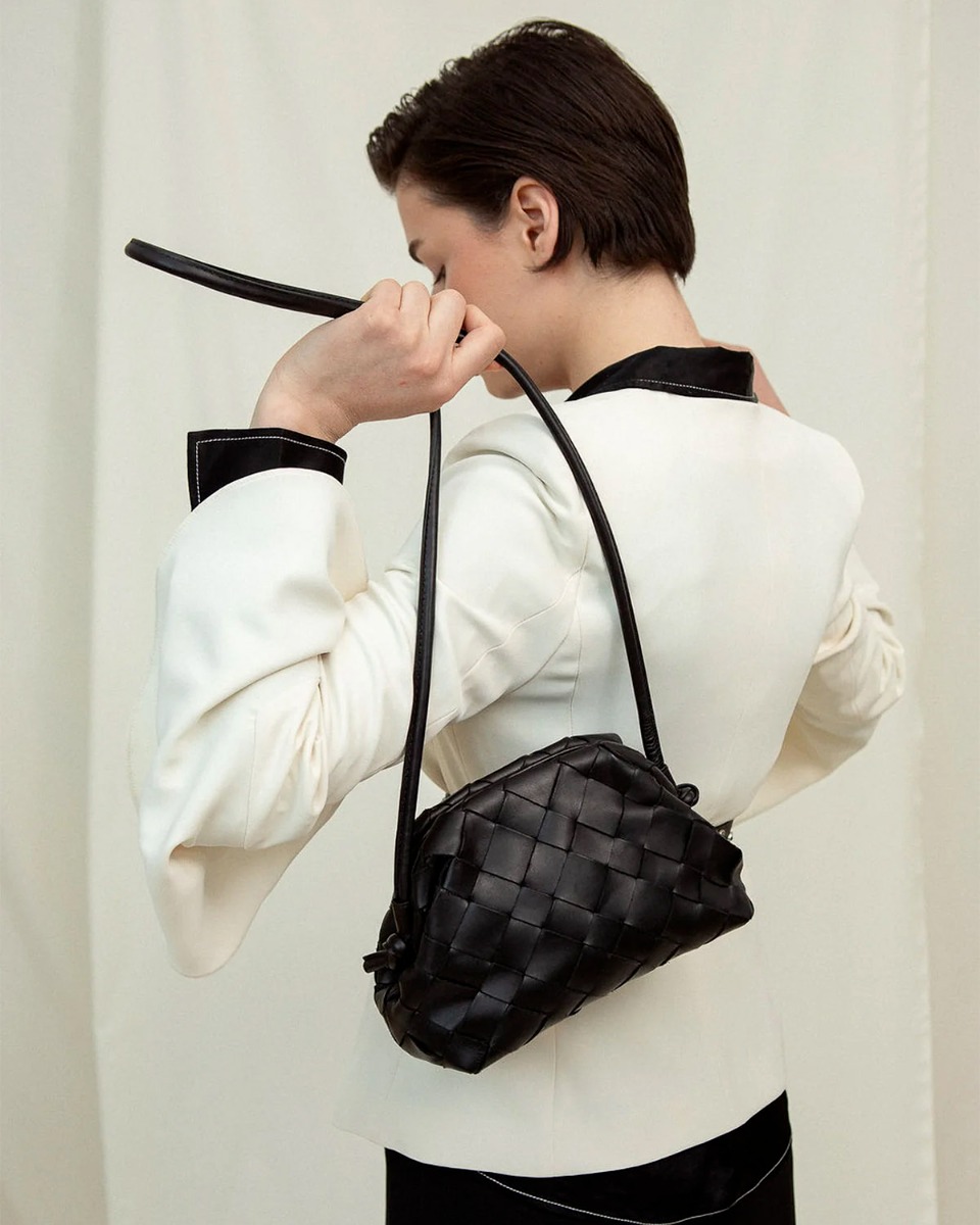 Mini sac pochette Aimee Cala Jade en cuir tress&eacute; Umber (marron tr&egrave;s fonc&eacute;). D&eacute;tail de la longue bandouli&egrave;re.