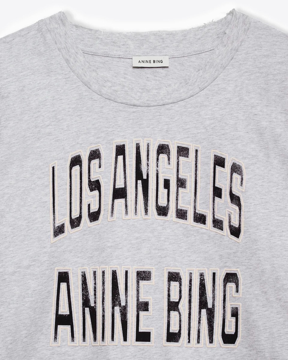 Tee-shirt court manches courtes encolure dégagée en coton gris chiné, logo sérigraphié "Los Angeles Anine Bing" Johnny Cropped Tee Anine Bing. Détail du col usé volontairement. 