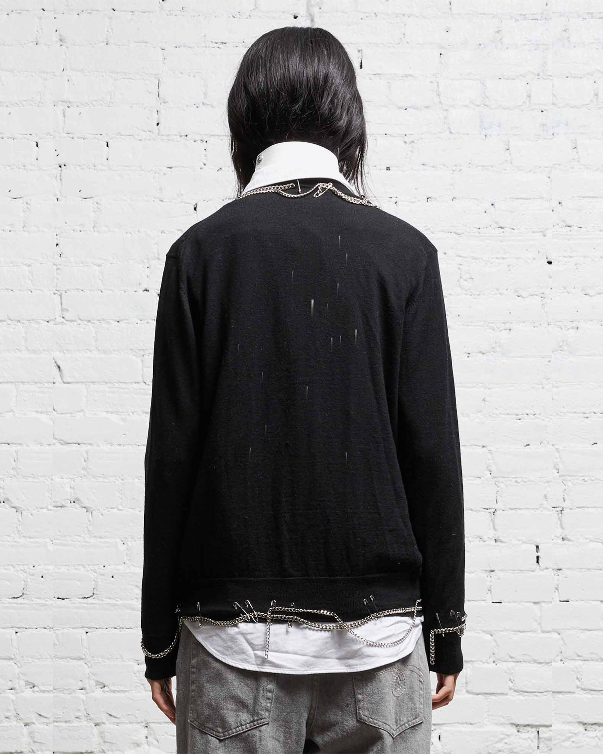 Cardigan noir avec chaines et épingles à nourrices R13 Denim. Porté dos. 