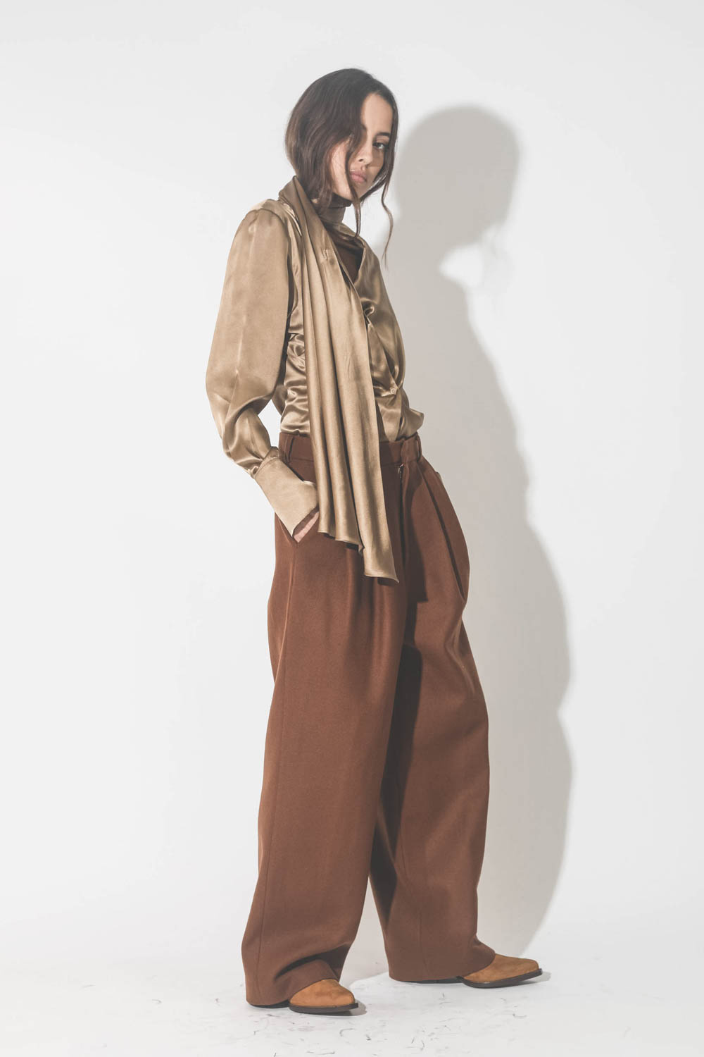 Chemise manches longues drapée col écharpe en satin de soie camel doré. Porté de profil.