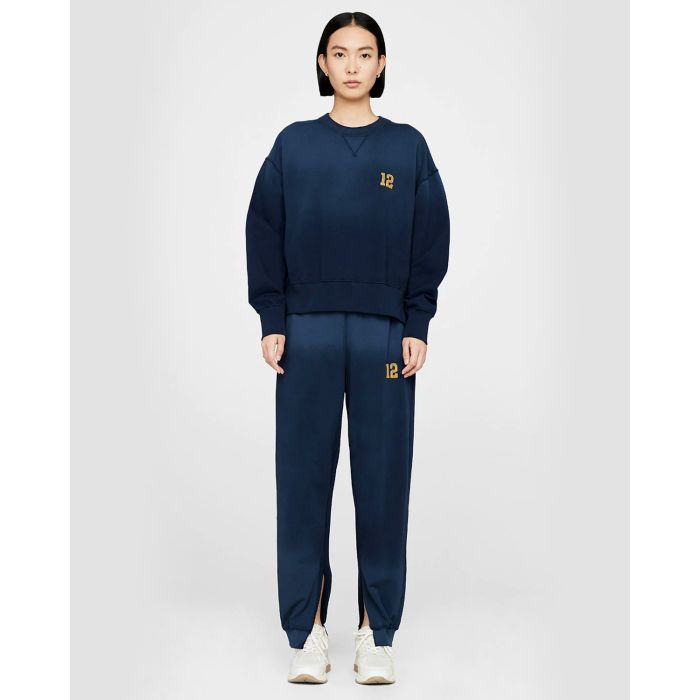Pantalon de jogging brodé ouvert en bas marine tie and dye Anine Bing. Porté face.