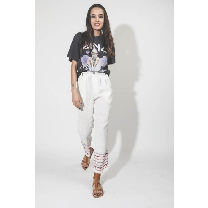 Pantalon en coton blanc bas de jambe brodé Alix of Bohemian. Porté avec des sandales.