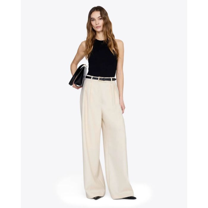 Débardeur emmanchures américaines Cole Anine Bing en maille côtelée noire, porté de face avec un pantalon large beige clair.