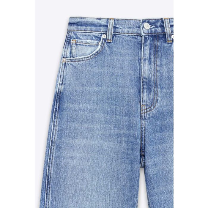 Jean taille haute ajusté Jane Anine Bing en denim bleu ciel délavage Cascade Blue. Détail du délavage bleu ciel avec usures volontaire au niveau des poches.