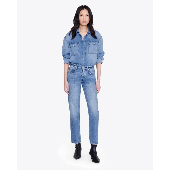 Jean taille haute ajusté Jane Anine Bing en denim bleu ciel délavage Cascade Blue, porté de face avec une chemise en jean assortie.
