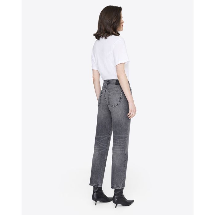 Jean taille haute Kate Anine Bing en denim gris délavé, porté de dos avec un tee-shirt blanc.