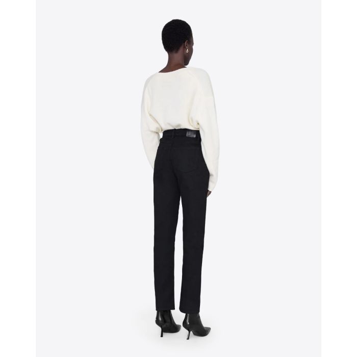 Jeans taille haute Bruno Anine Bing en toile noire. Porté de dos avec un pull en cachemire écru.