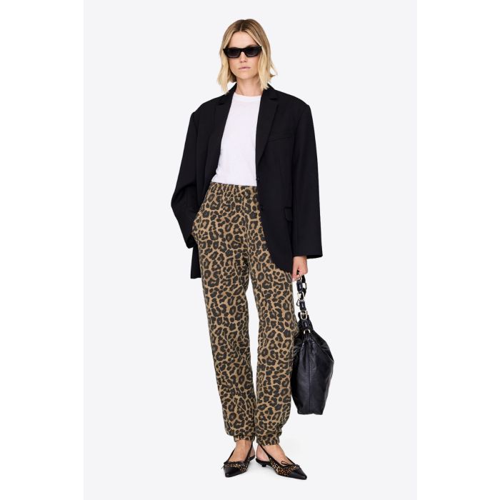 Pantalon de jogging Karter Anine Bing en coton imprimé léopard, porté avec un blazer noir et des ballerines. 