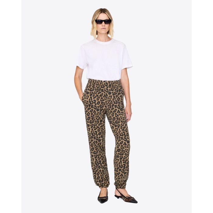 Pantalon de jogging Karter Anine Bing en coton imprimé léopard, porté de face avec un tee-shirt blanc.