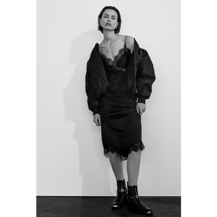 Jupe longue Shelby noire Anine Bing en satin et dentelle esprit lingerie portée avec un blouson noir.
