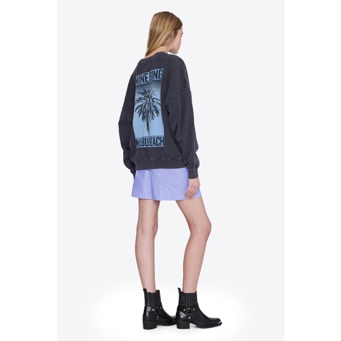 Sweatshirt Miles Palm Anine Bing en coton noir délavé sérigraphier palmier bleu dans le dos, logo « ANINE BING » sur le poitrine porté de dos.