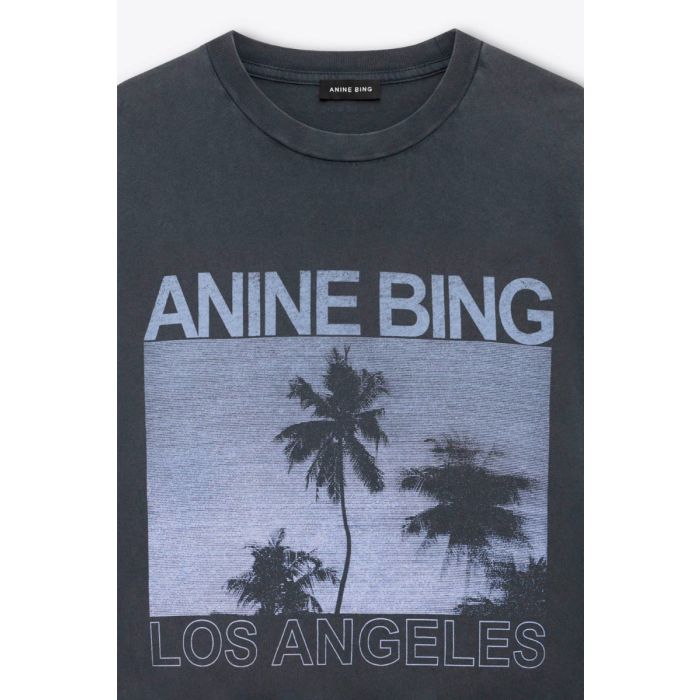 T-shirt manches courtes Cade Palms Anine Bing en jersey de coton fluide noir délavé sérigraphie avec les palmiers mythique de Los Angeles fond bleu et logo ANINE BING. Détail du col et de la sérigraphie.