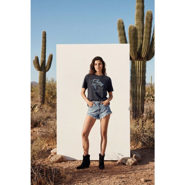 T-shirt manches courtes Kent Eagle Anine Bing en coton noir délavé, sérigraphie aigle et logo « Bing » bleu, porté de face avec un short en denim bleu.