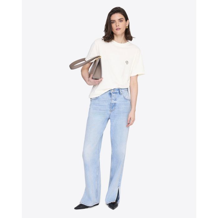 Tee-shirt manches courtes Wagner Soft Stencil Anine Bing en coton crème, logo AB poitrine, sérigraphie dans le dos, porté de face avec un jean taille haute.