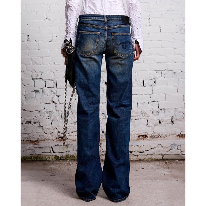 Jean Boy Flare taille basse évasé bleu délavé r13. Porté avec une pochette noire. 