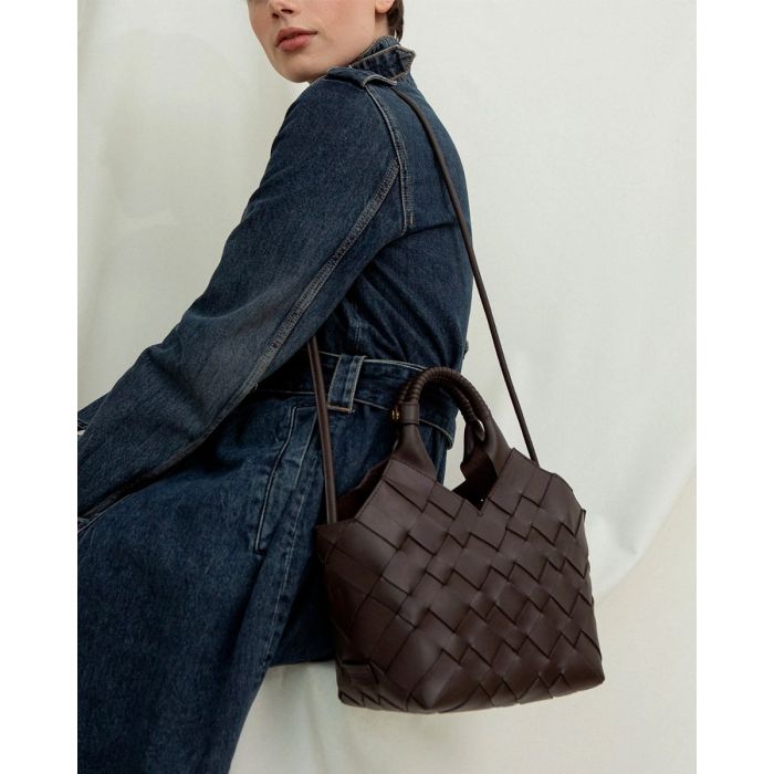 Sac Misu Cala Jade en cuir tressé noir, porté à l'épaule avec la bandoulière longue.