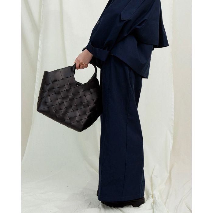 Sac Misu Large Cala Jade en cuir tressé noir, porté de profil.