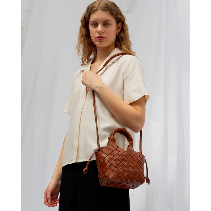 Sac Misu mini Cala Jade en cuir tressé Nutmeg, porté à l'épaule avec la bandoulière longue.