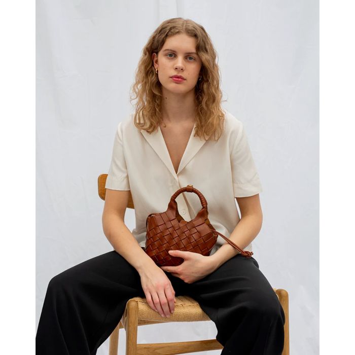 Sac Misu mini Cala Jade en cuir tressé Nutmeg, porté dans les mains.