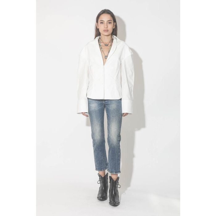 Collier oeil saphir sur cordon tressé en fil de soie métallique Patricia Arango. Porté avec une chemise blanche et un jeans. 