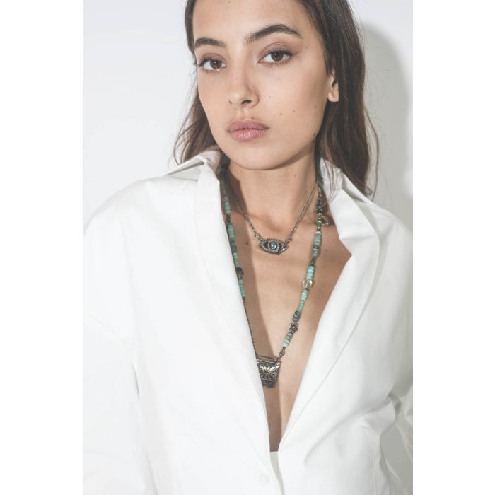 Collier oeil saphir sur cordon tressé en fil de soie métallique Patricia Arango. Porté avec un sautoir.