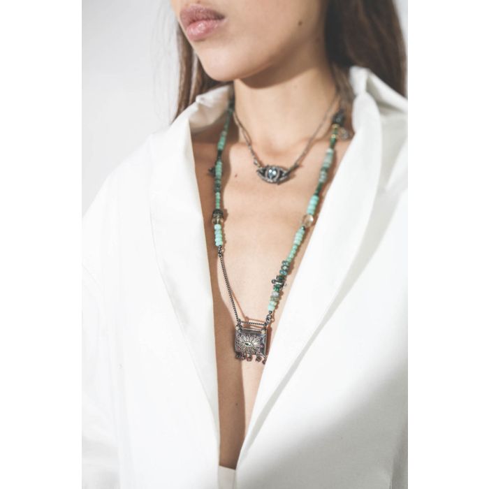Collier oeil saphir sur cordon tressé en fil de soie métallique Patricia Arango. Porté en accumulation.