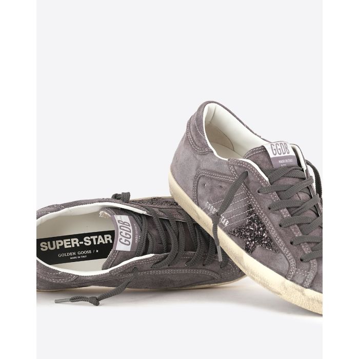 Sneakers Superstar Golden Goose femme en daim gris, étoile à paillettes. Détail des lacets.