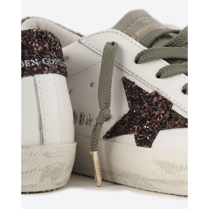 Sneakers Superstar Golden Goose femme en cuir blanc avec étoile et talon arrière à paillettes marron. Détail de l'étoile à paillettes marron.