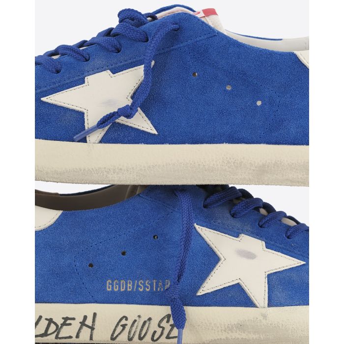 Sneakers Superstar Golden Goose homme en cuir suédé bleu, étoile blanche, arrière en cuir blanc. Détail de la matière et de l'effet usé volontairement.