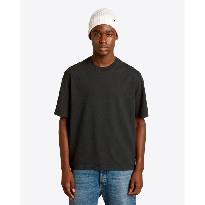 Tee-shirt Relaxed Fit Golden Goose Unisexe en coton noir logo « GOLDEN » inversé dans le dos, porté de face.