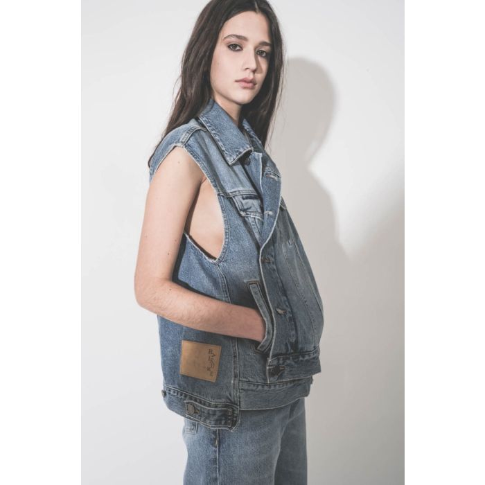 Veste sans manches oversize Janette Haikure en jean bleu délavé Nordic Blue, portée fermée et croisée. Détail des poches.