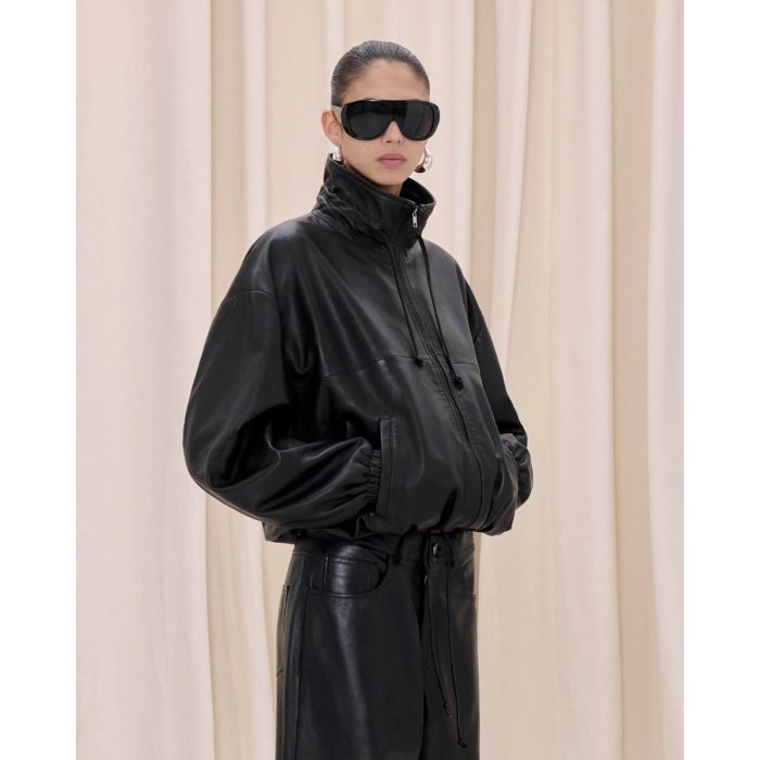 Blouson Jordan Haikure en cuir nappa noir, porté de profil col montant zippé.