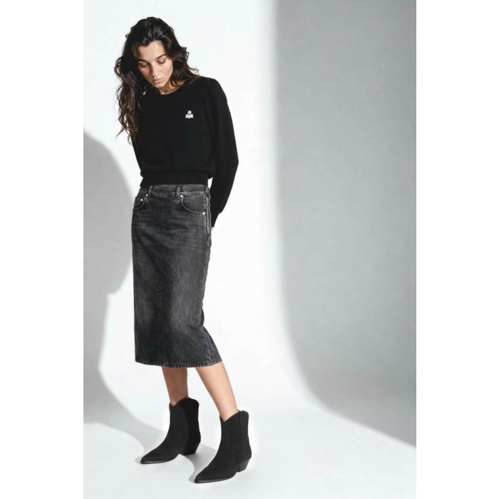 Jupe Kim Haikure en denim gris foncé. Portée avec des boots noires. 
