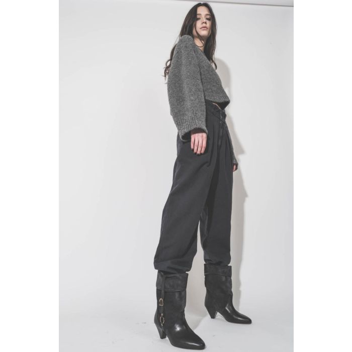 Boots Darner Buckle Isabel Marant en cuir suédé noir délavé et en cuir lisse noir, portées de profil avec un pull gris en alpaga Thibault Van Der Straete et un pantalon large Isabel Marant Etoile.