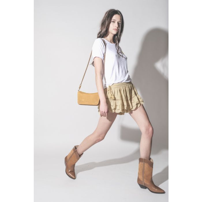 Bottes santiags Duerto Isabel Marant en cuir suédé et cuir lisse châtaigne, portées de profil avec un short en dentelle ocre Isabel Marant Etoile et un sac Bobi S Jérôme Dreyfuss.