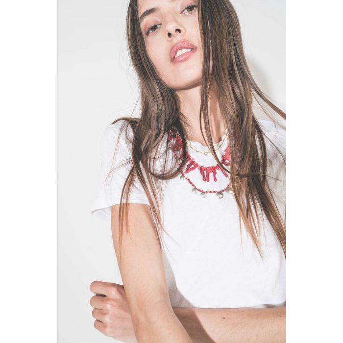Collier de perles et os rouges Jolana Isabel Marant. Porté de face en accumulation avec un collier coquillage Noki et un collier Adriel en perles rouges et pampilles en métal argenté Isabel Marant. 