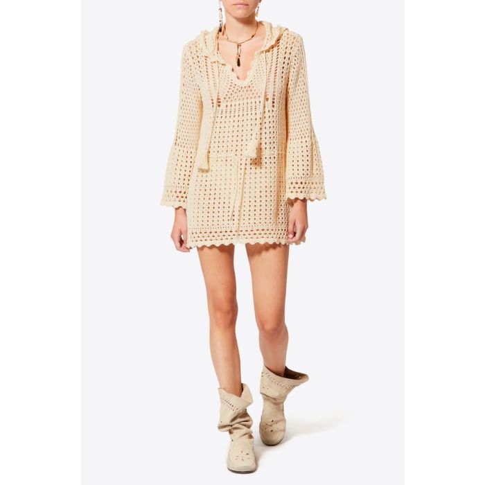 Robe courte manches longues à capuche Zelnie Isabel Marant Etoile en crochet écru, portée de face avec des bottes souples en daim écru.