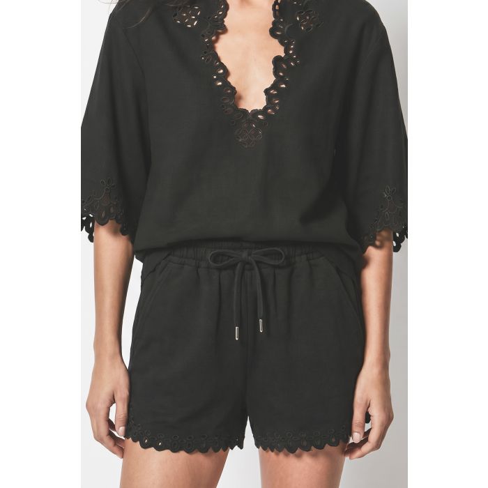 Short Balyme Isabel Marant Étoile en coton noir à broderies anglaises ajourées porté avec la blouse Balyme assortie. Détail du lien de serrage à la taille. 